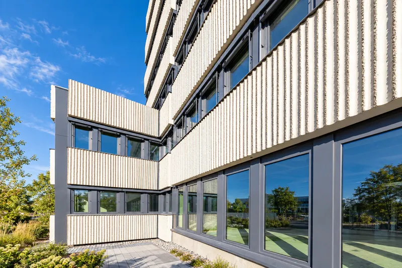 Building corner with ribbed panels and large ground-floor windows