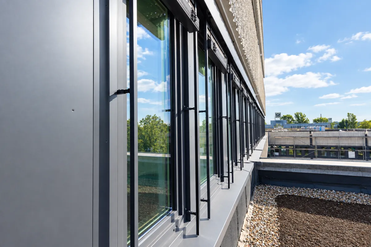 Row of windows on the roof terrace with the new window sill and insulated slate-gray aluminum cladding
